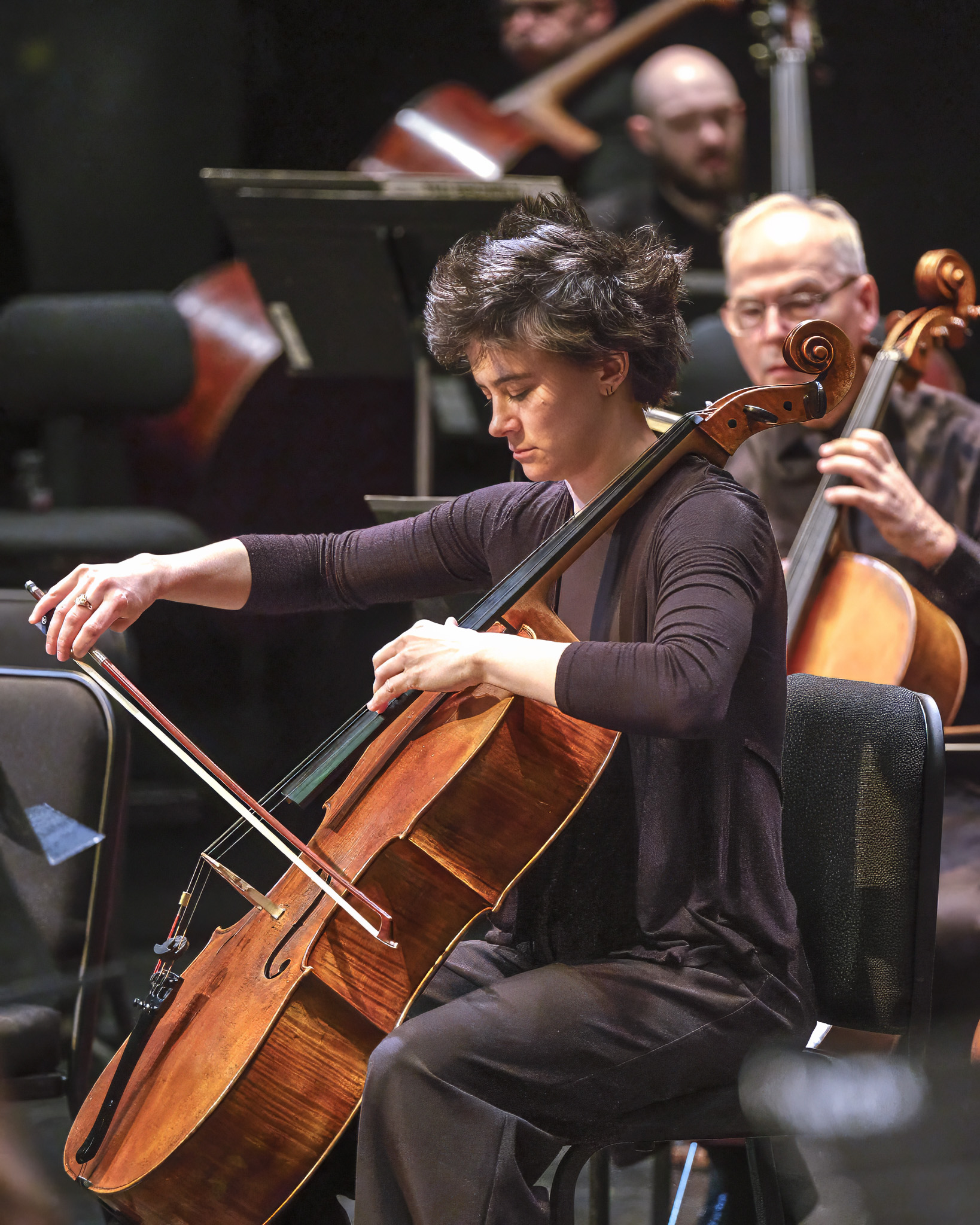 Hannah Paulus performing cello with an orchestra on stage
